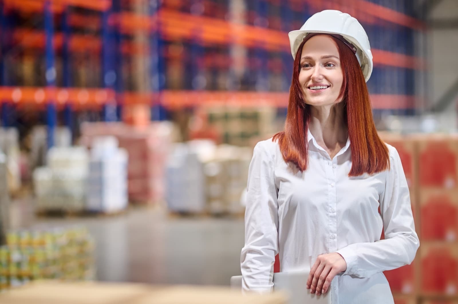Warehouse lead checking orders from a laptop on the floor